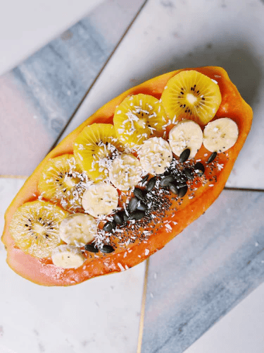 A tropical papaya fruit cut in half and filled with a colorful combination of seamoss and various fruits is called a "Seamoss Papaya Boat.